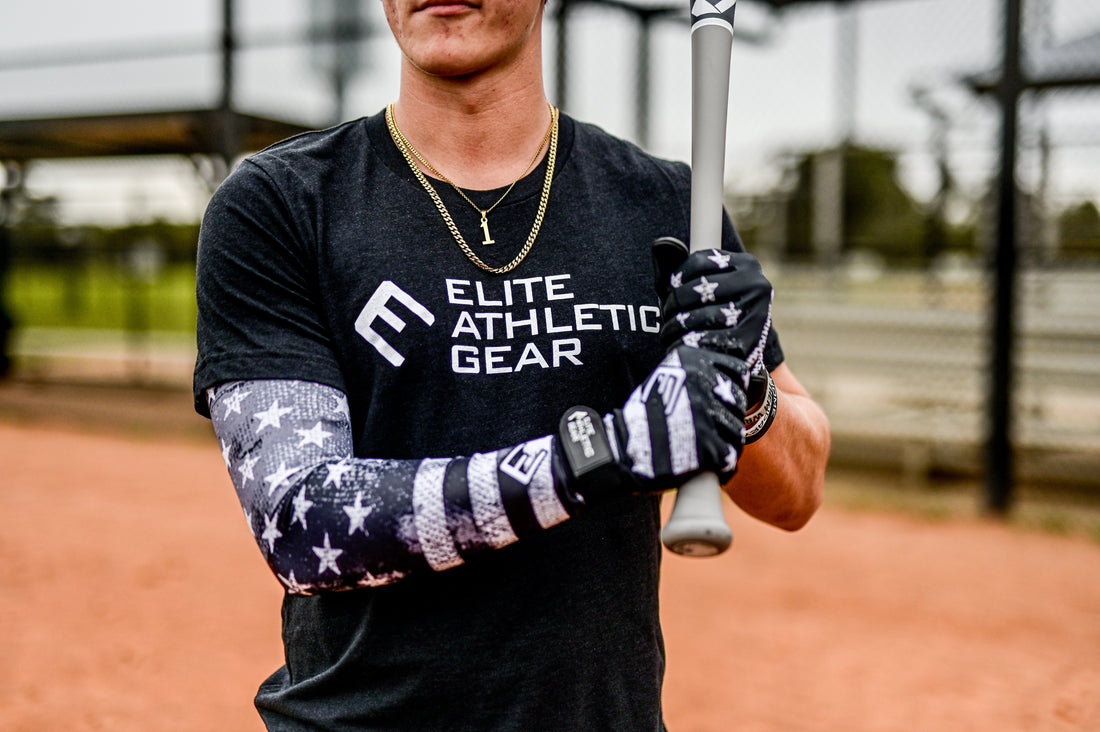 baseball player wearing a black and white american flag compression arm sleeve while holding a baseball bat.